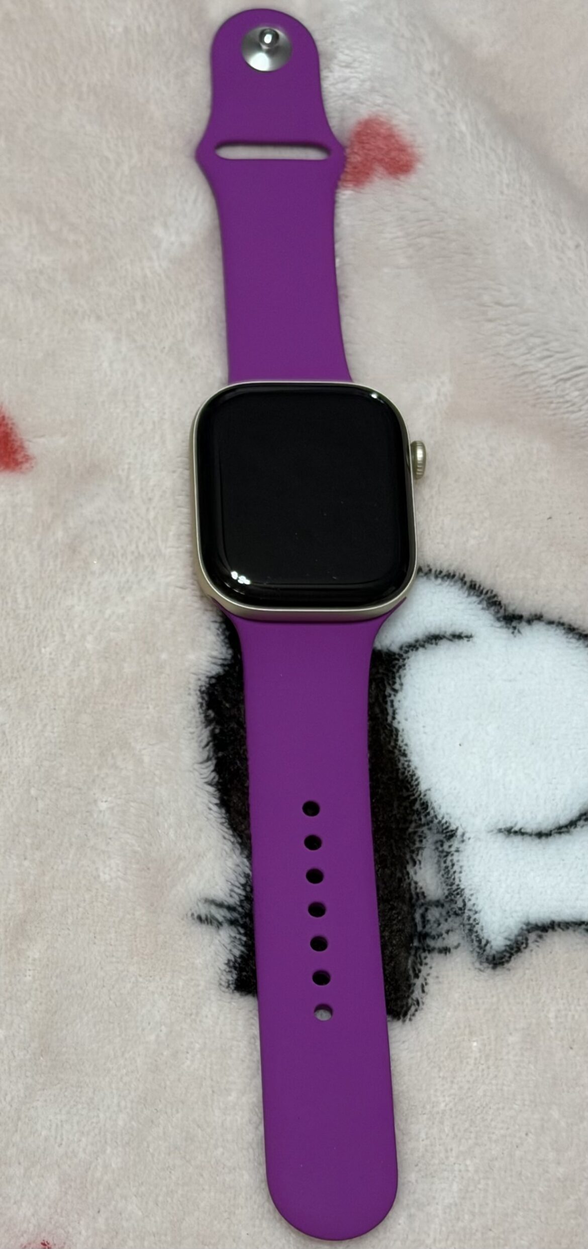 Apple Watch Series 12 dourado com pulseira magenta visto de frente.